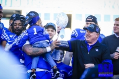20191231-Stoops-and-Bowden-Hold-Trophy-hidden-by-Child